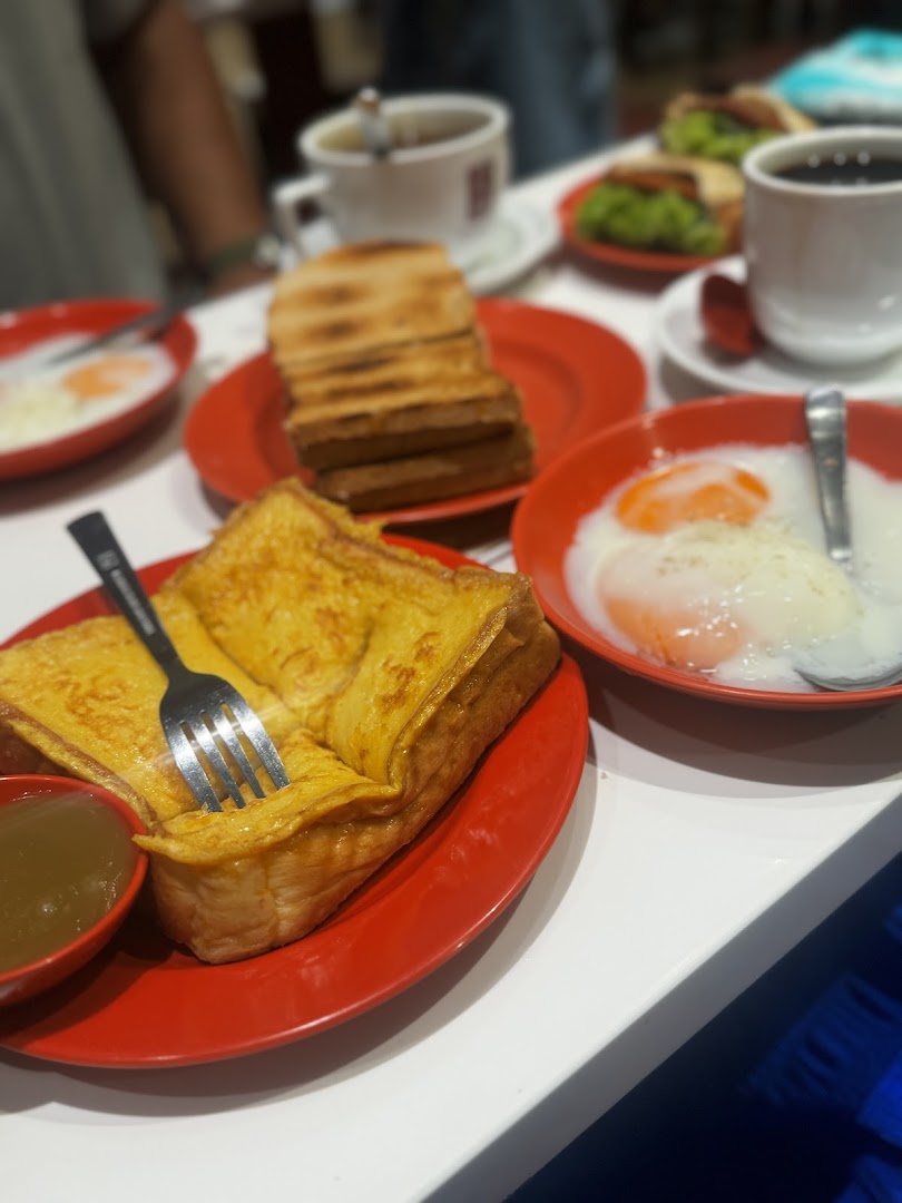 A table with French toast, soft-boiled eggs, coffee, and toast slices.