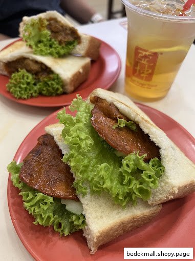 Two sandwiches with lettuce and a drink on a table.