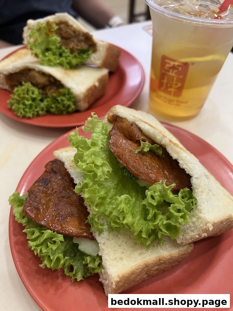 Two sandwiches with lettuce and meat, and a drink on a table.
