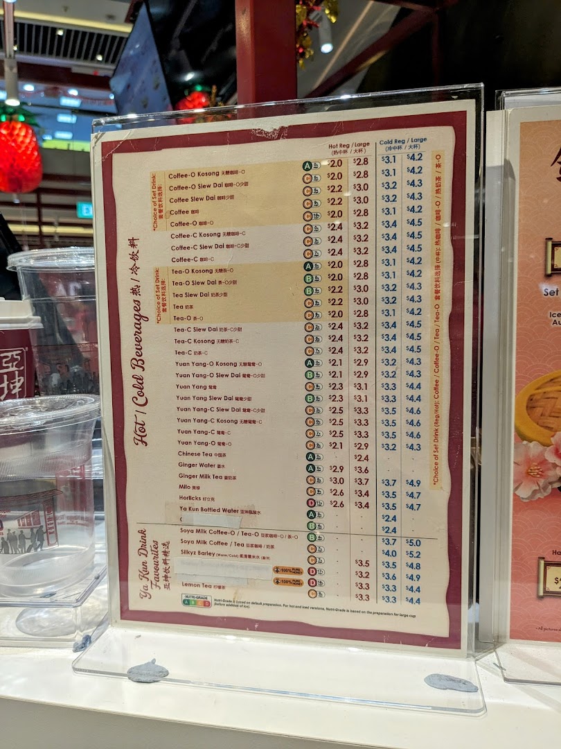 A detailed menu board displaying hot and cold beverages with prices at Ya Kun Kaya Toast.