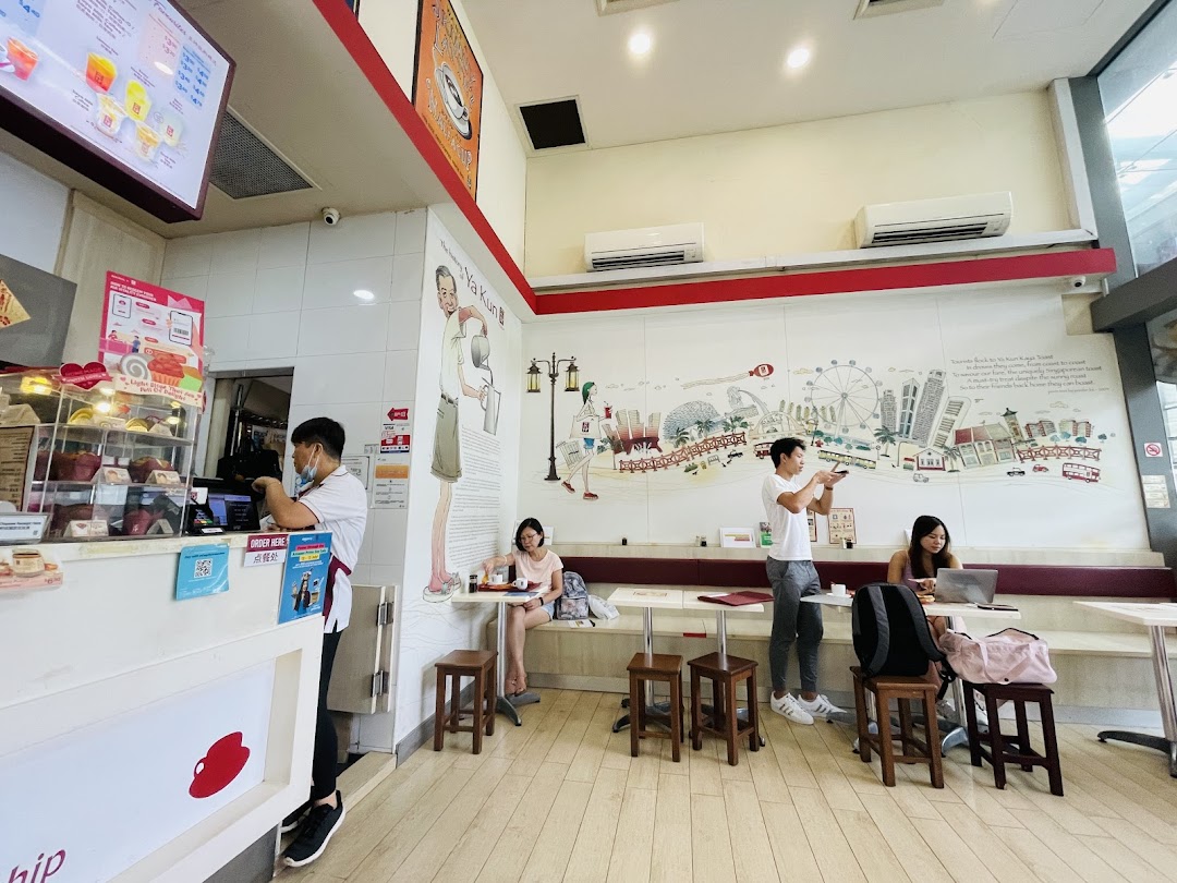 Interior of a cafe with customers, staff, counter, and seating area.