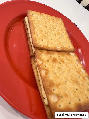 Two square crackers with filling served on a red plate.