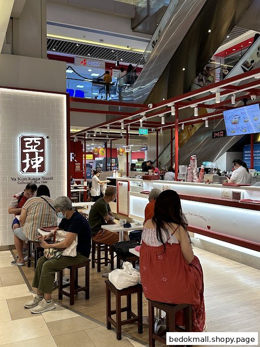 People dining and waiting inside a Ya Kun Kaya Toast outlet in a mall.