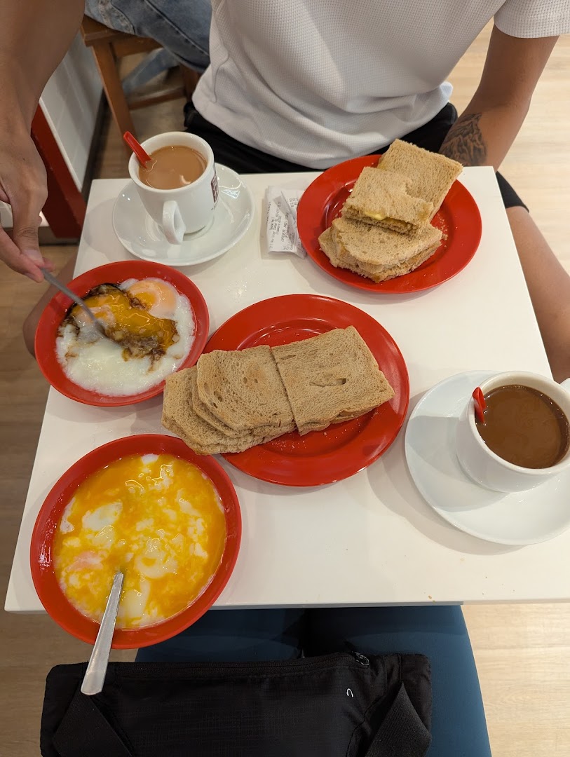 Table with toast, soft-boiled eggs, and drinks at a cafe.