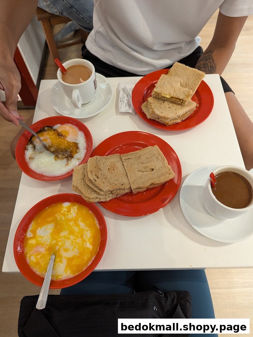 Table with toast, soft-boiled eggs, and drinks at a cafe.