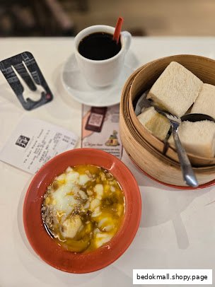 Coffee, soft-boiled eggs, and steamed bread on a table.