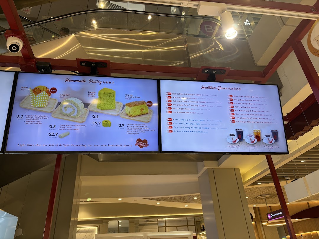 Digital screens displaying pastries, drinks, and prices at Ya Kun Kaya Toast.