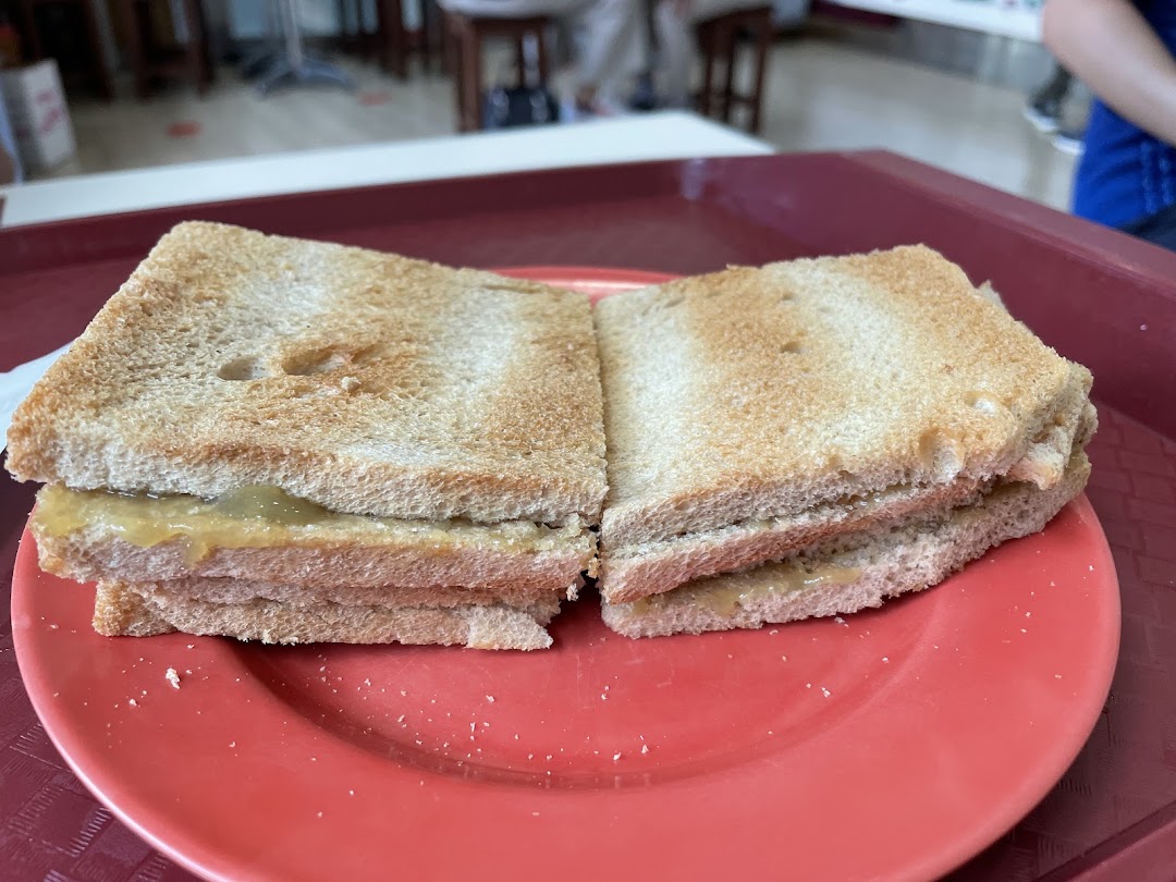 Two pieces of kaya toast on a red plate.