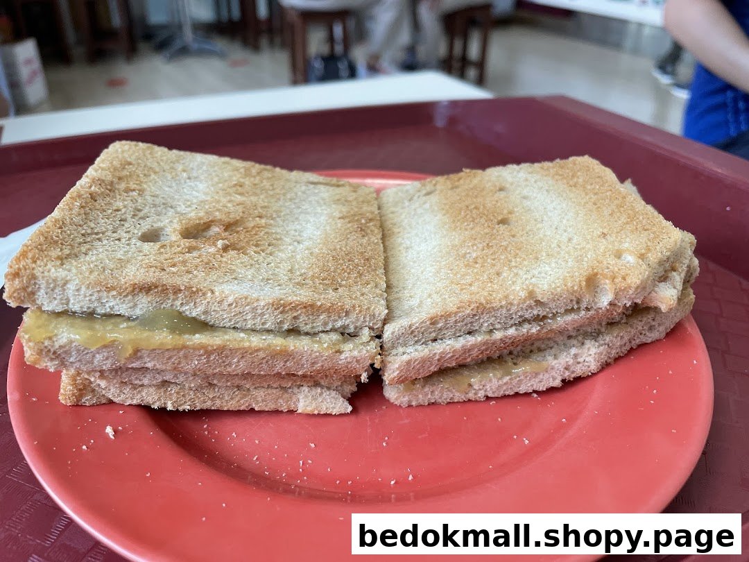 Two pieces of kaya toast on a red plate.