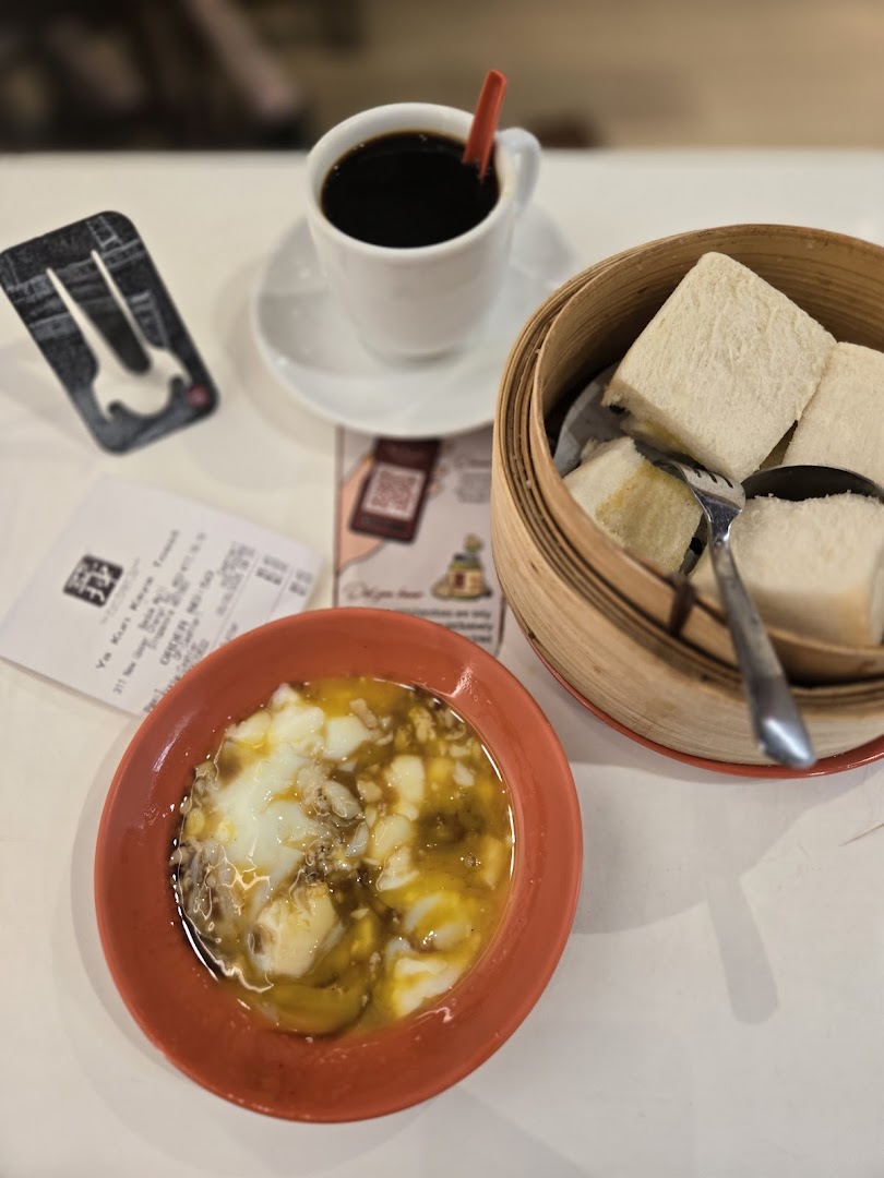 Coffee, soft-boiled eggs, and kaya toast served on a table.