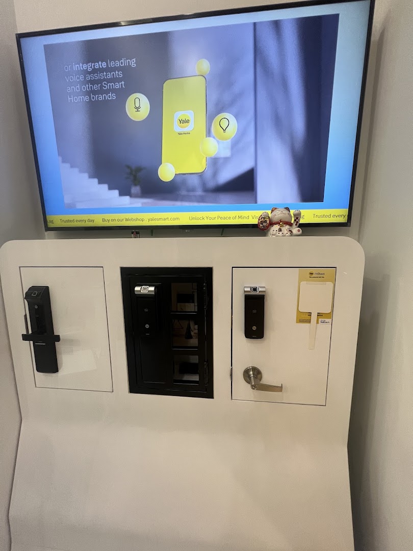 Interior display of smart locks and a TV screen showing Yale products.