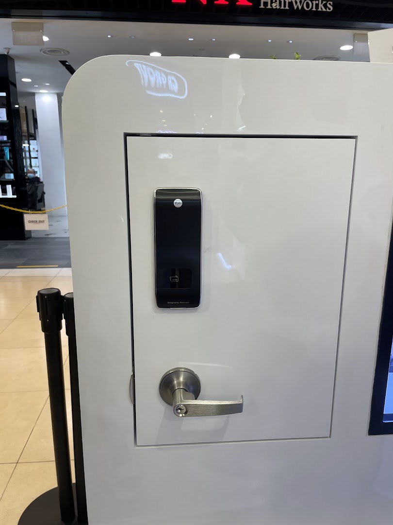 White display stand showcasing a Yale smart lock and door handle.