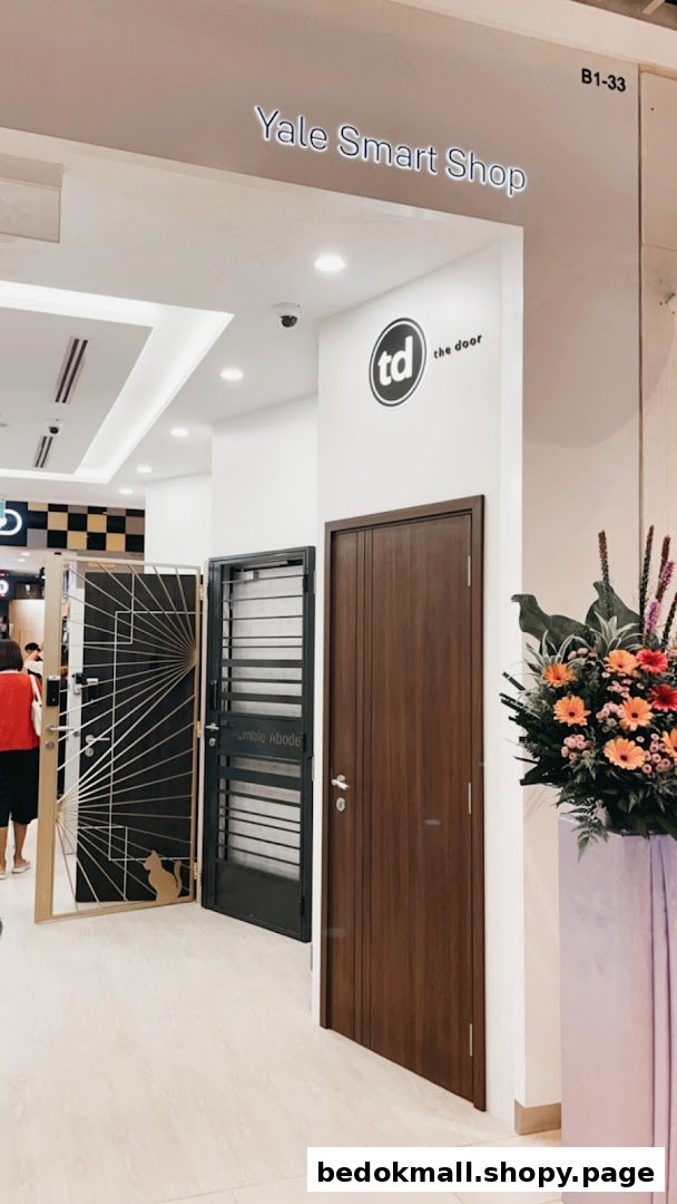 Entrance of Yale Smart Shop displaying various doors and gates with a floral arrangement.