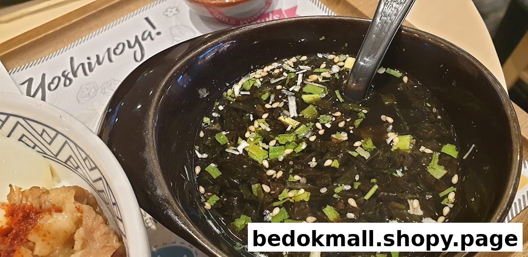 Close-up of a bowl of seaweed soup and another dish on a table.