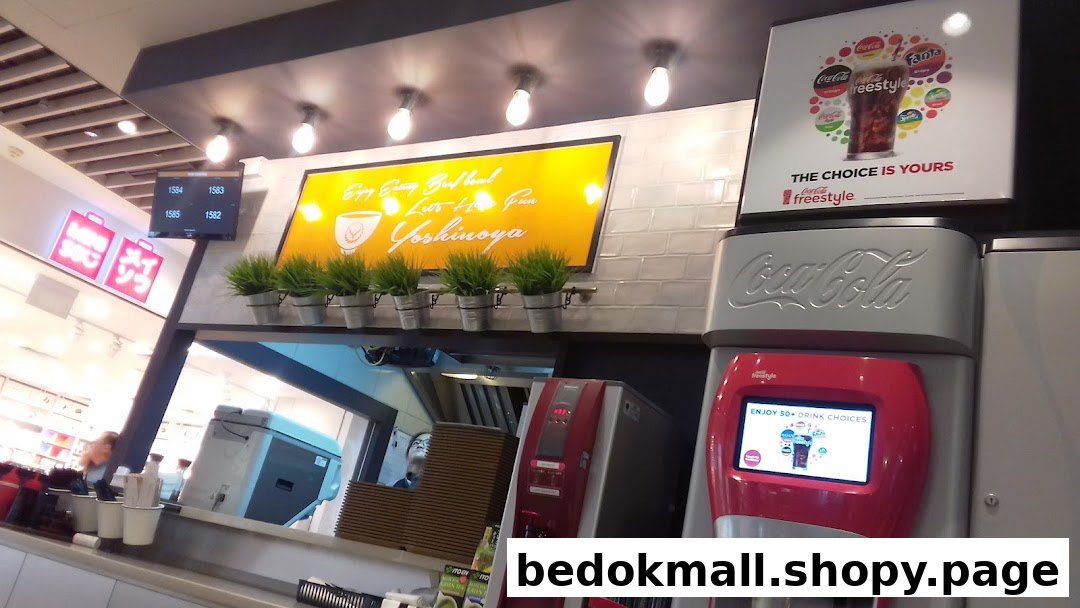 Interior view of Yoshinoya counter with a Coca-Cola Freestyle machine and signage.