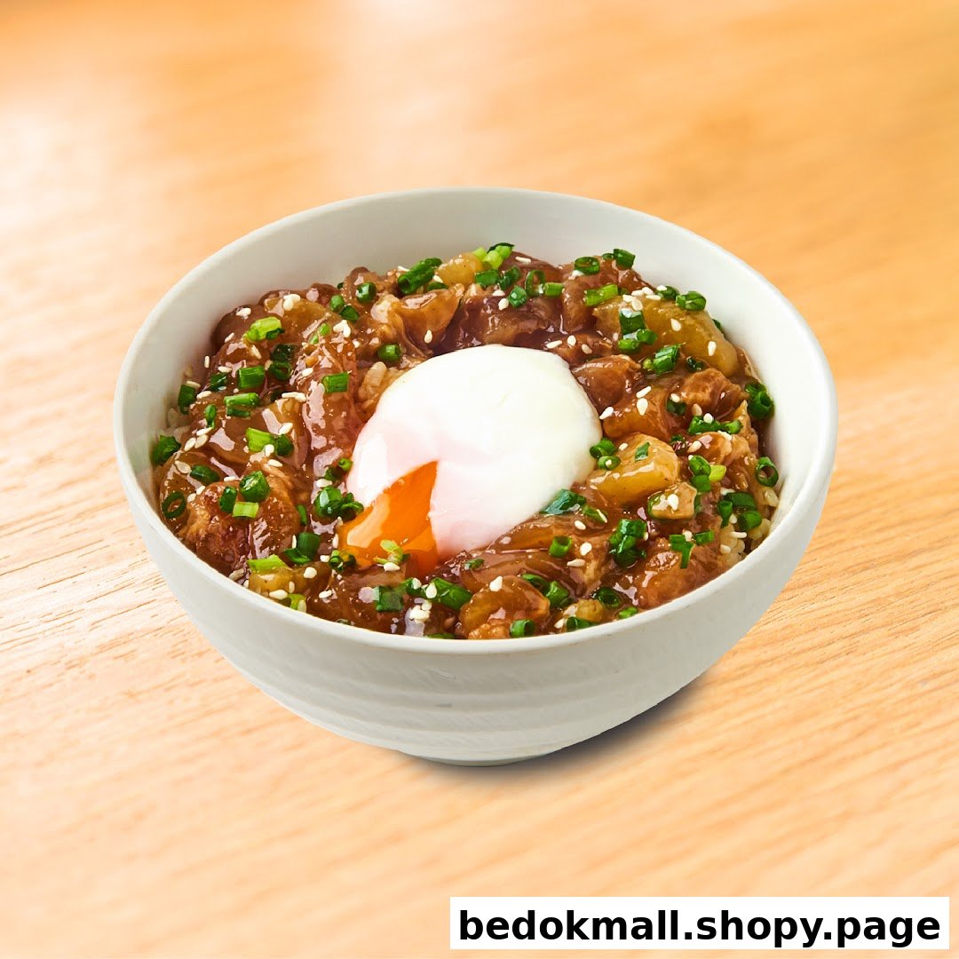 A bowl of beef and onion rice with a poached egg and green onions.