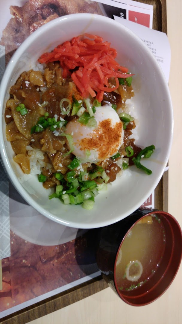A bowl of donburi with meat, egg, and red ginger, served with miso soup.