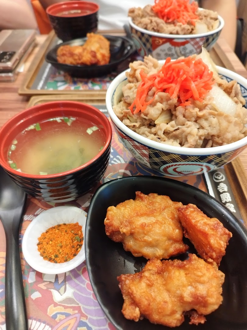 Multiple beef bowls, fried chicken, and miso soup on a table.