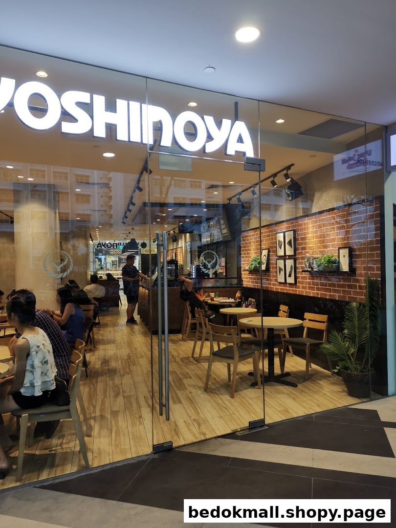 Glass entrance of Yoshinoya restaurant with customers seated inside.