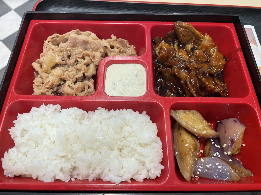 A red bento box filled with rice, beef, and vegetables.