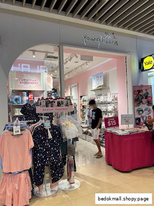The image shows the shop front of Young Hearts with clothing displays and a person entering.