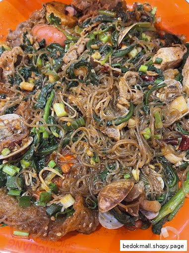 Close-up of a Mala Tang dish with noodles, vegetables, meat, and clams.