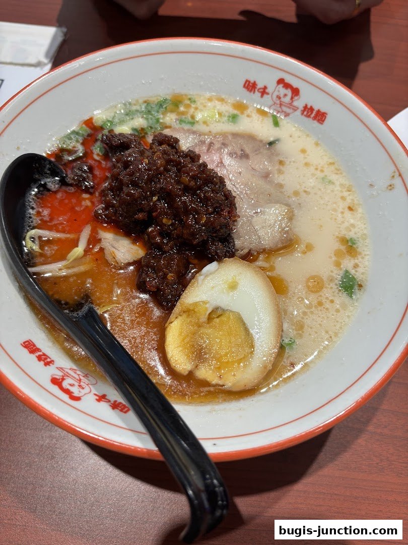 A bowl of Ajisen Ramen with pork, egg, and chili paste.