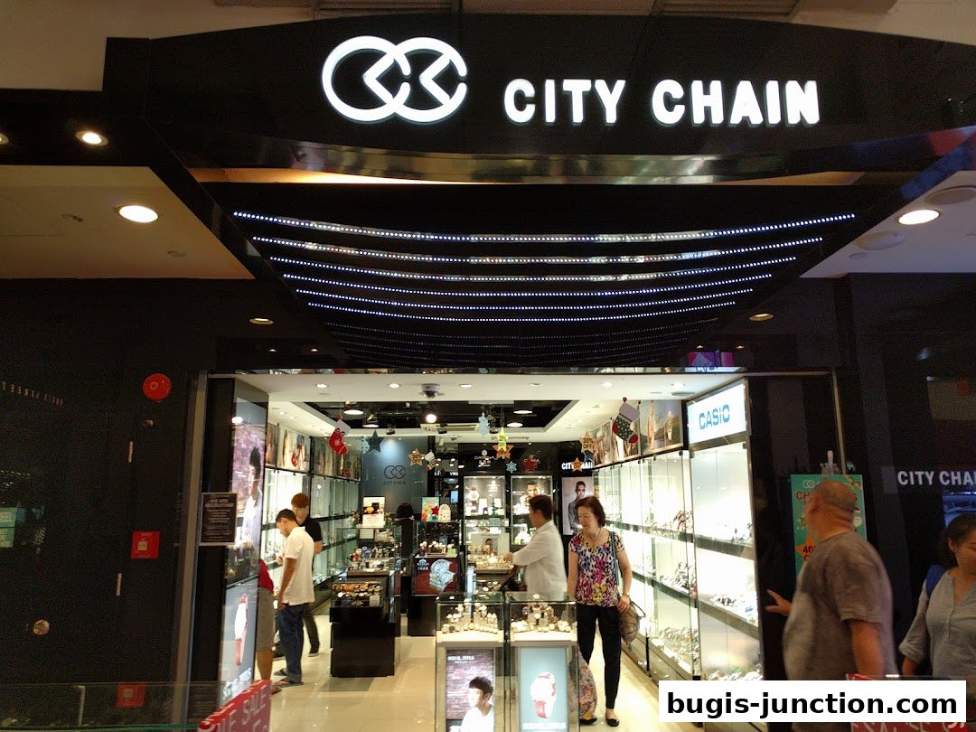 The entrance of a City Chain store, showcasing watches and accessories displayed in illuminated cabinets.