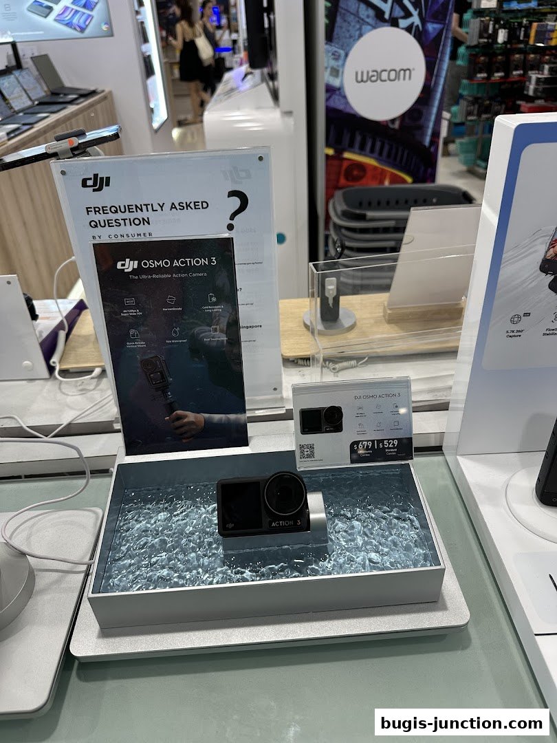 A DJI Osmo Action 3 camera is displayed in a store, with promotional materials and other electronics visible.