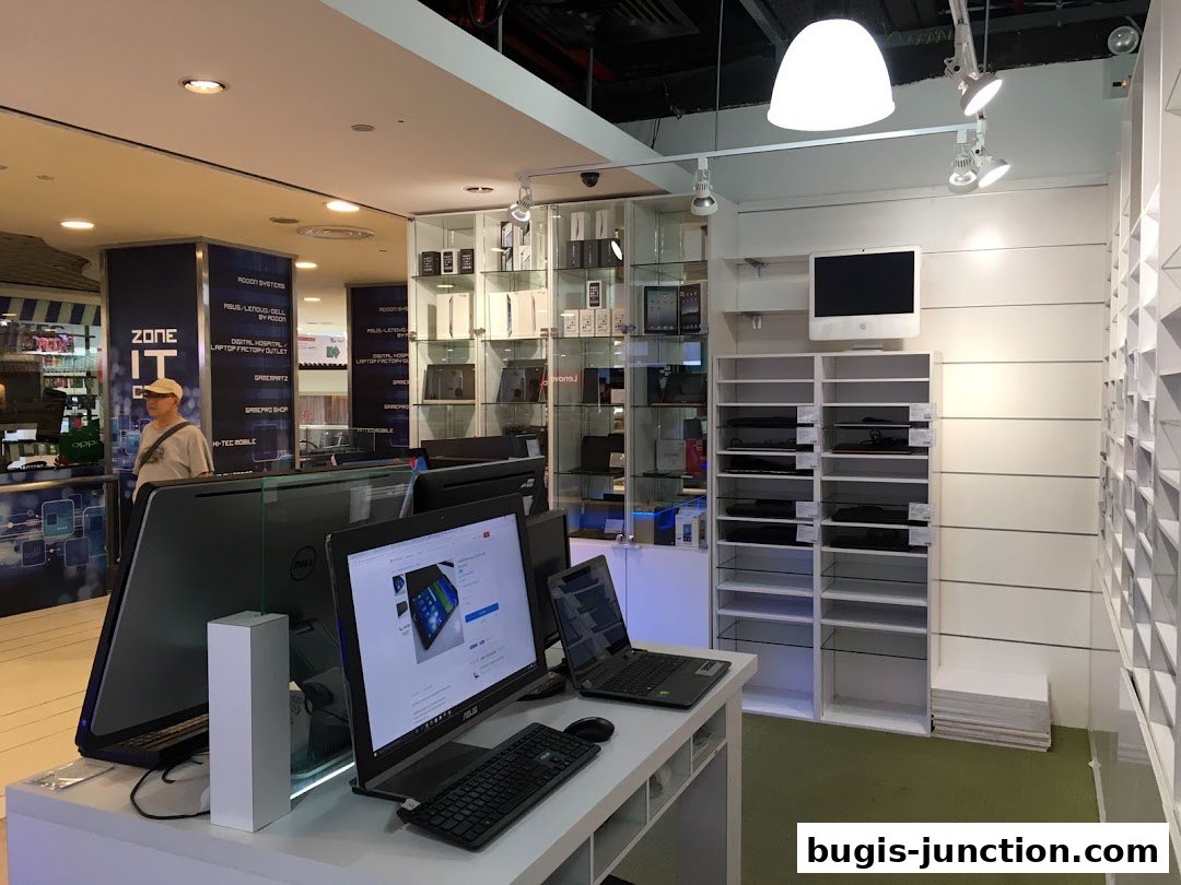Interior view of a tech store showcasing laptops, computers, and accessories on display.