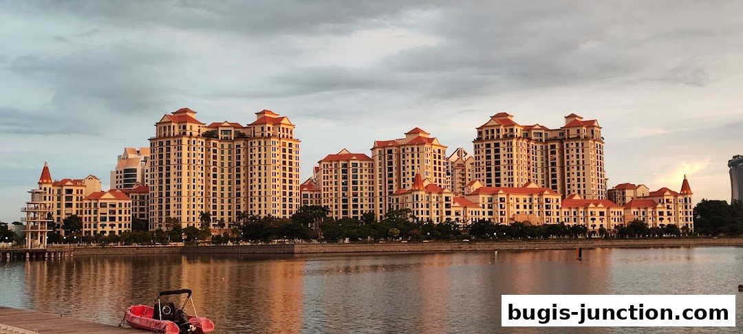A scenic view of waterfront buildings with a red boat in the foreground.