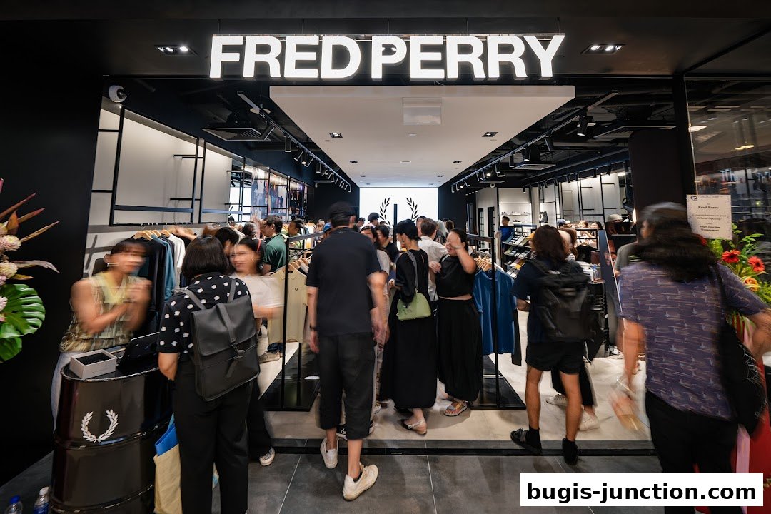 People browsing inside a Fred Perry store with clothing displays and a prominent sign.