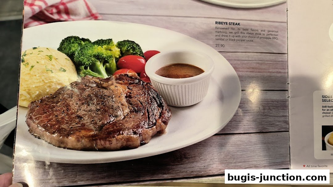 A delicious Ribeye Steak with mashed potatoes, broccoli, and tomatoes, served with sauce.