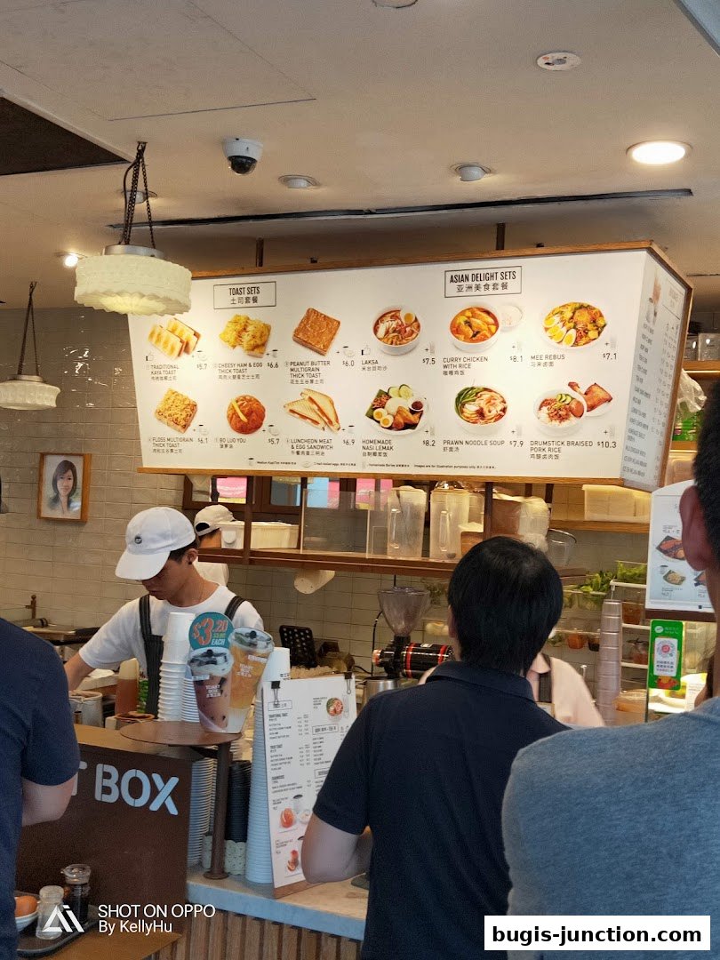 A menu board displaying various toast and Asian delight sets with prices.
