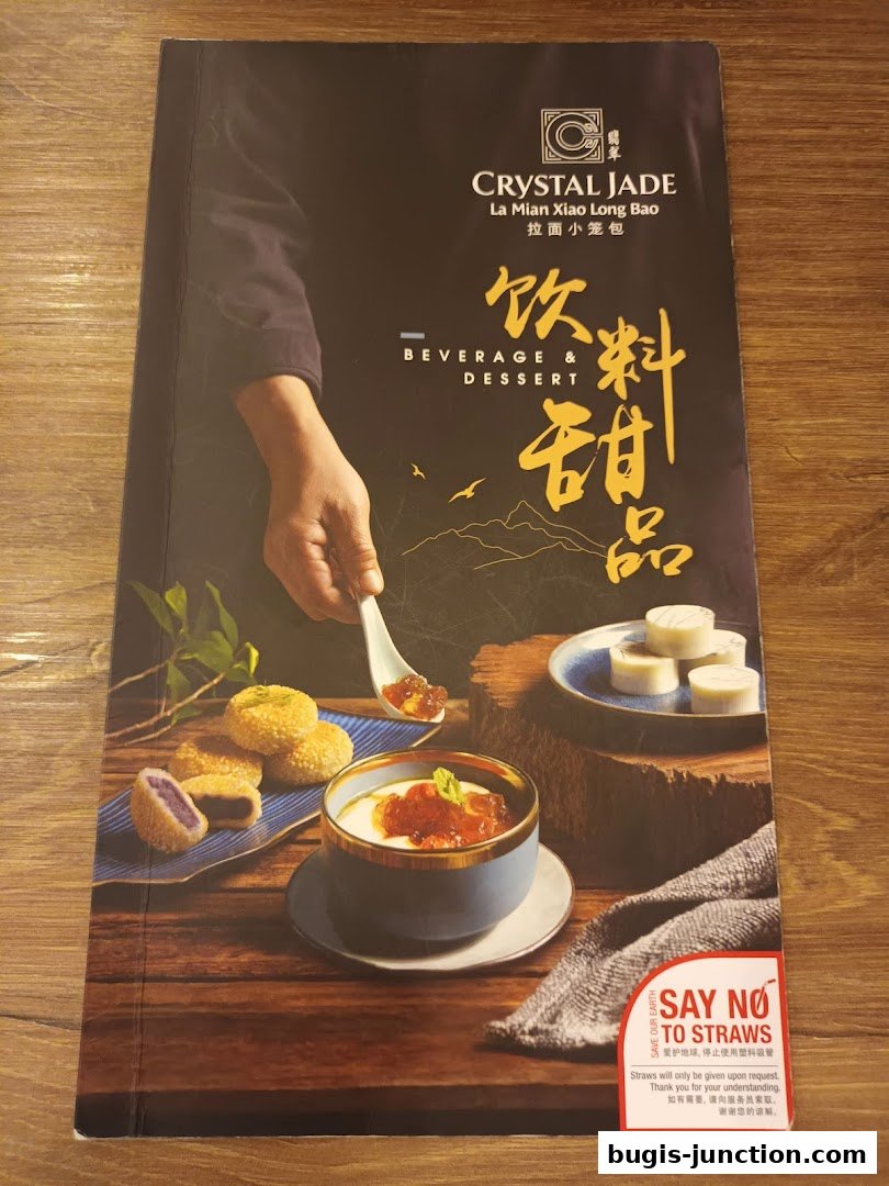 A menu cover for Crystal Jade La Mian Xiao Long Bao featuring beverages and desserts.