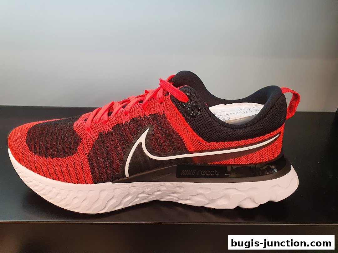 A red and black Nike running shoe with a white sole is displayed.