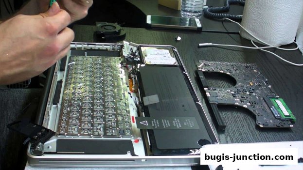 A person is repairing a laptop, with components like the motherboard and keyboard visible.