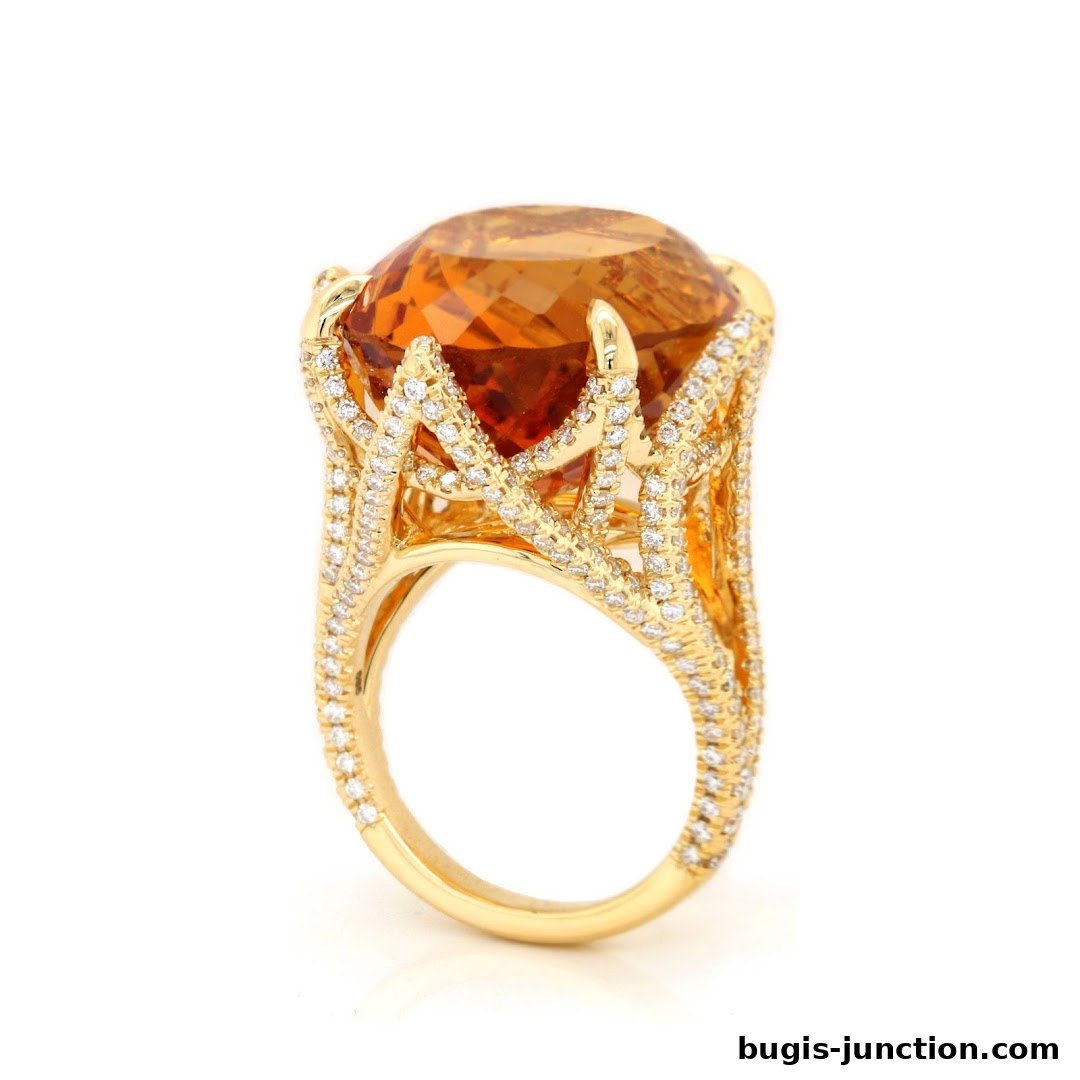 A stunning gold ring with a large orange gemstone and diamond accents.