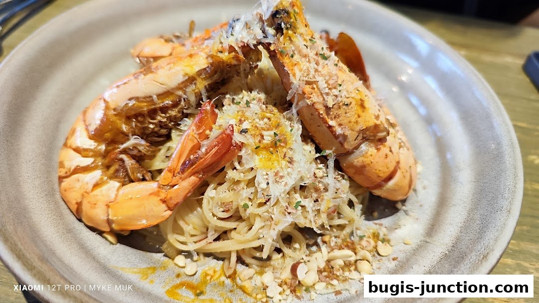 A close-up shot of a delicious pasta dish with large grilled prawns and a sprinkle of cheese.