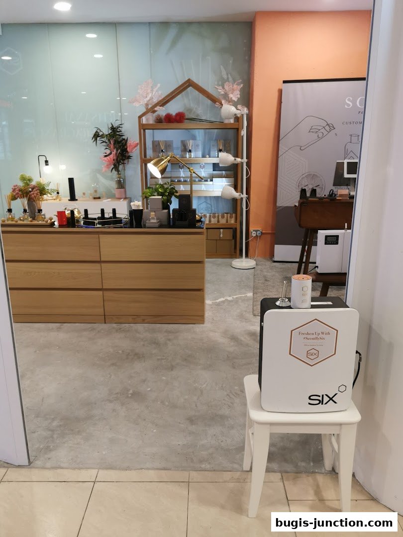 Interior view of a modern retail shop with wooden displays showcasing perfumes and diffusers.