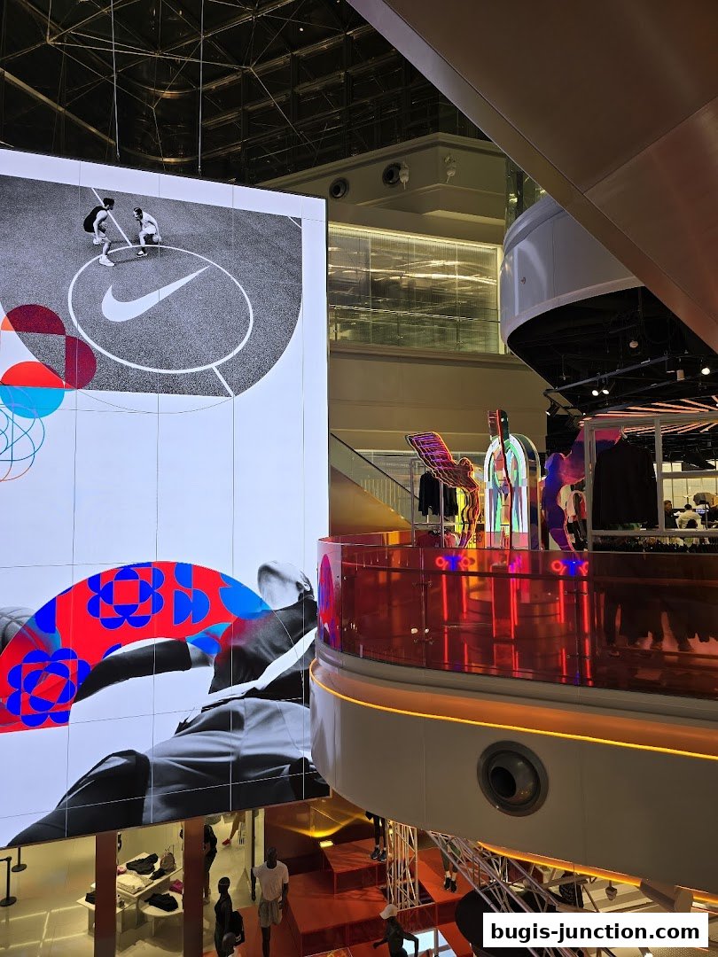 Interior view of a modern Nike store with large digital displays and merchandise.