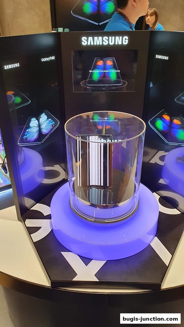 Samsung Galaxy Fold display with interactive screens and a central product showcase.