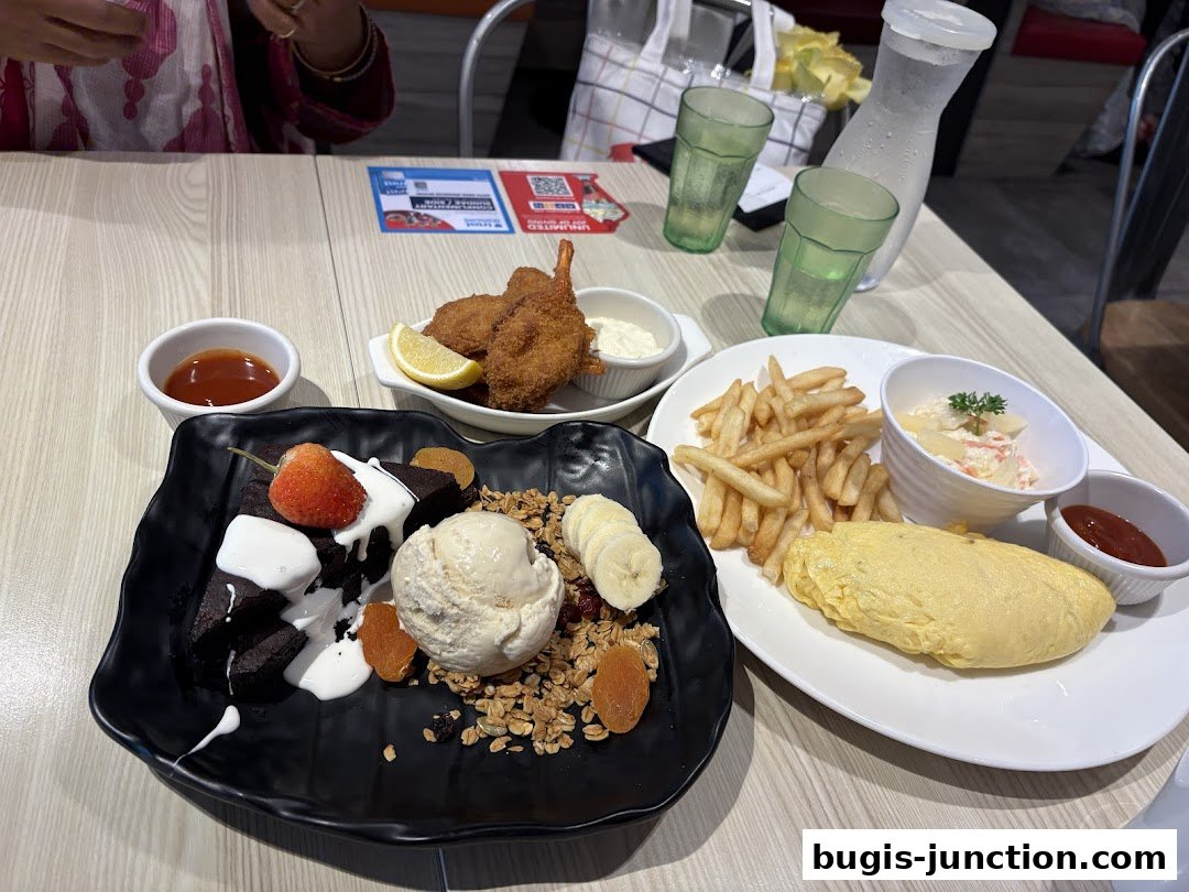 A table laden with various dishes including dessert, fried shrimp, fries, and an omelet.