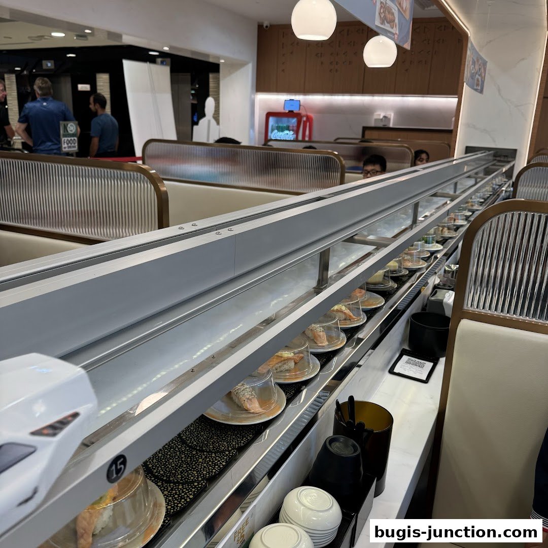 Interior of a sushi restaurant with a conveyor belt filled with sushi dishes.