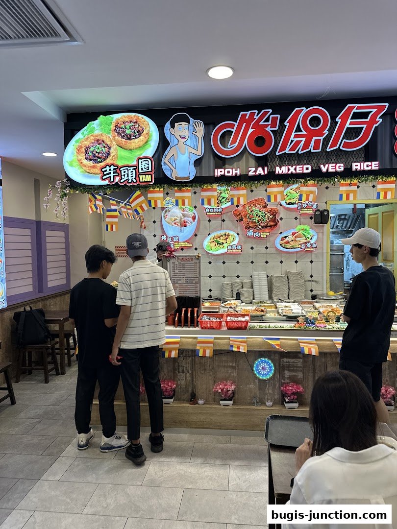 People ordering food at a stall with a menu board displaying various dishes.