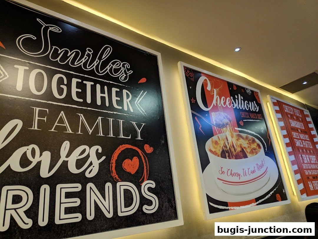 Wall art with inspirational quotes and a poster of a cheesy dish at Eighteen Chefs.