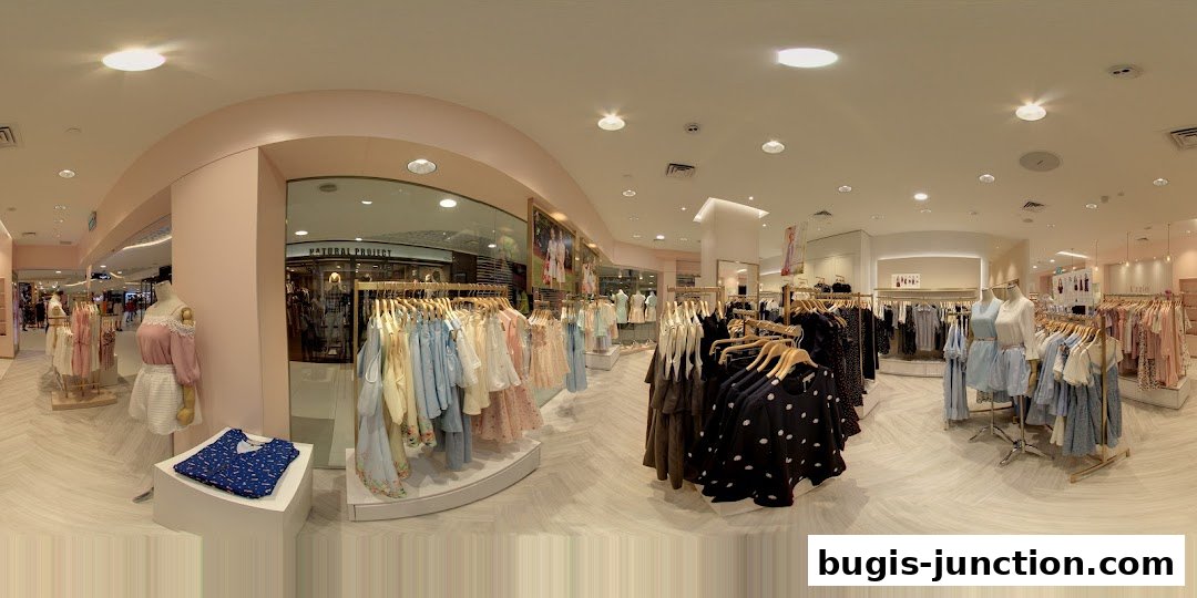 Interior view of a clothing store with racks of dresses and mannequins displaying outfits.