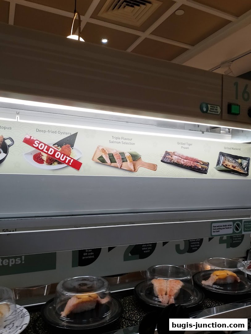 A conveyor belt sushi restaurant with various sushi dishes displayed.