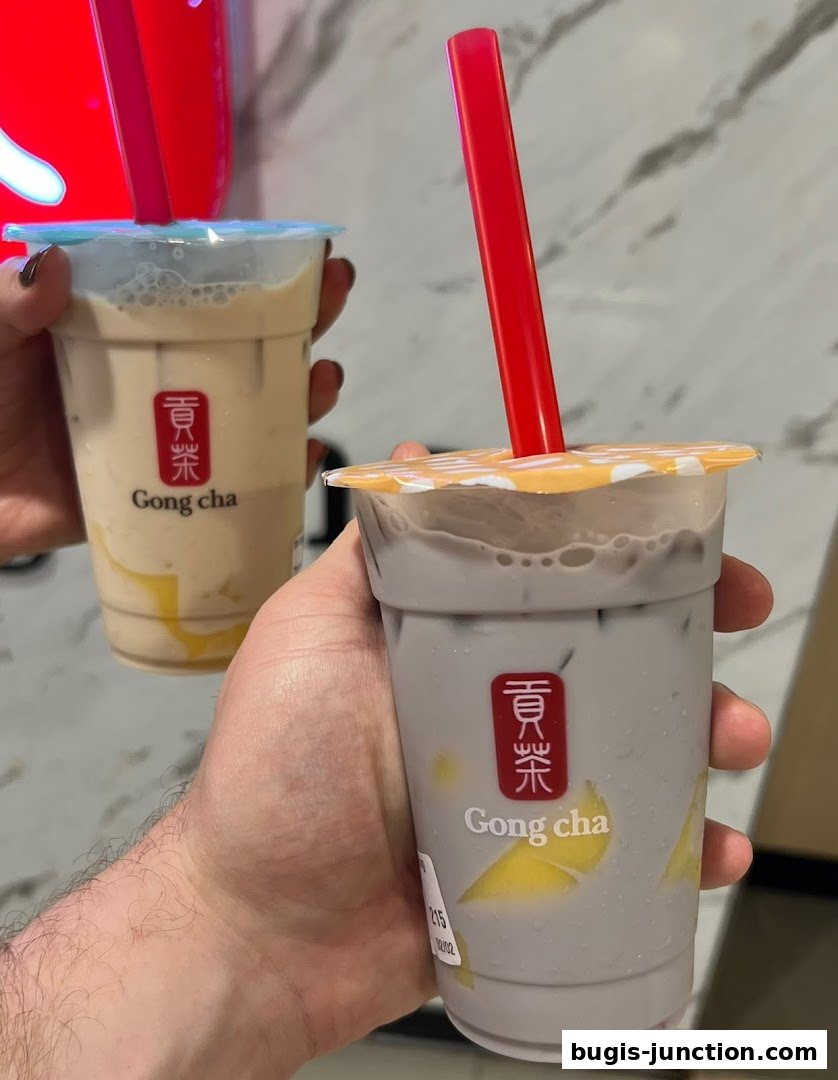 Two hands holding bubble tea drinks from Gong Cha.