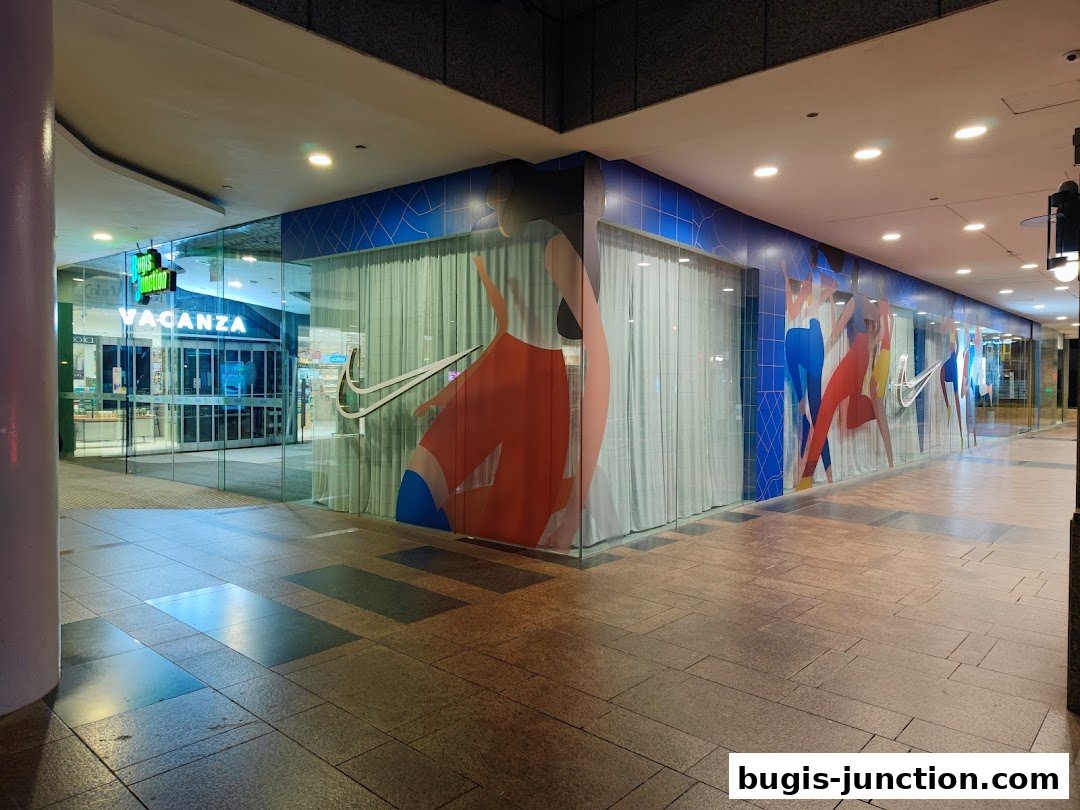 The exterior of a Nike store with large glass windows featuring athletic graphics and the Nike logo.